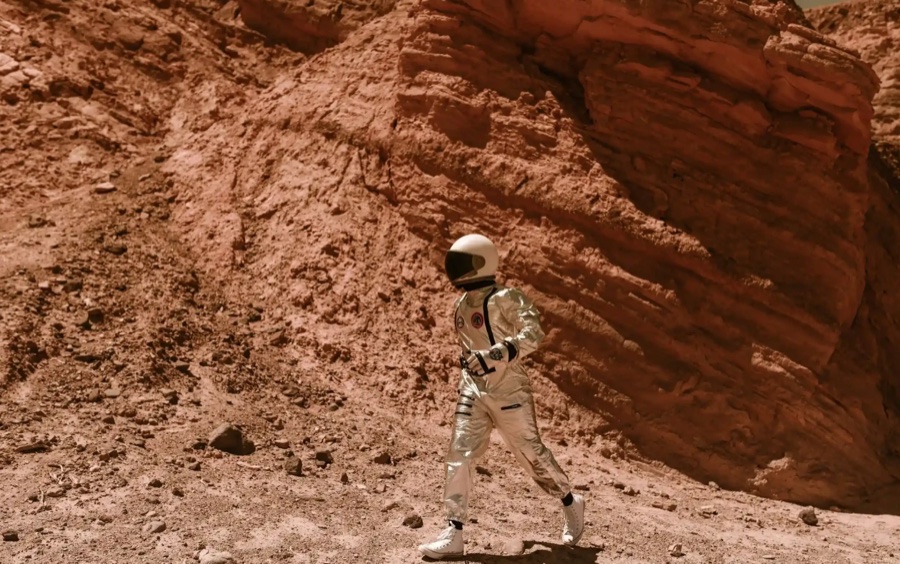An astronaut walking through a red-rock canyon, from 11x's brand world